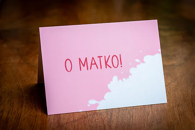 Kartka dla mamy „O Matko!” — odręczny napis na tle rozlanego mleka